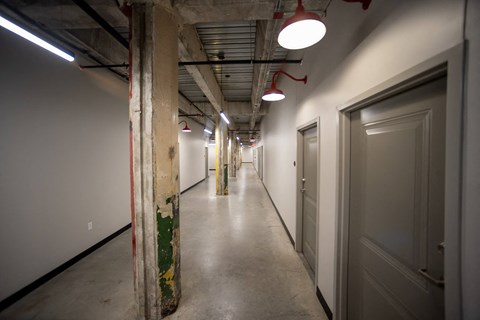a view down a long corridor with white walls and grey doors at Conwood Flats, Memphis, TN, 38107